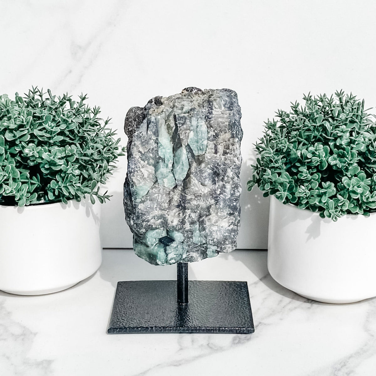 S1766 Raw Emerald crystal stone on black metal stand australia. emerald on a stand home office decor australia. gemrox sydney 1